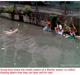 Young boys brave the smelly waters of a Manila 'estero' to collect floating debris that they can later sell for cash