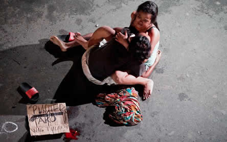 A woman cradles the lifeless body of her loved one, a victim of vigilante killing in the Philippines. Photo: Thomson Reuters