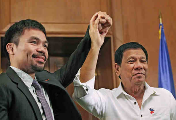 President Rodrigo Duterte raises the hand of Sen. Manny Pacquiao during a courtesy call at Malacaan in December 2016.